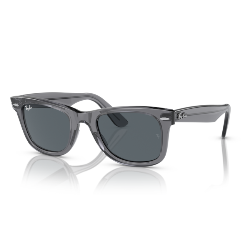 Occhiali da sole unisex Ray-Ban 2140 WAYFARER 6773R5 con montatura in acetato grigio trasparente lucido e lenti blu tinta unita. Il design squadrato iconico della linea Wayfarer si rinnova con una finitura moderna e una protezione UV affidabile